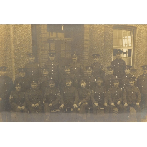 91 - A LARGE GLAZED FRAME WITH A WWI PERIOD PHOTO OF A COMPANY OF SOLDIERS, in uniform, believed RAMC, to... 