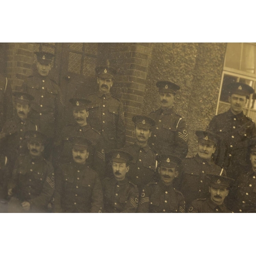 91 - A LARGE GLAZED FRAME WITH A WWI PERIOD PHOTO OF A COMPANY OF SOLDIERS, in uniform, believed RAMC, to... 