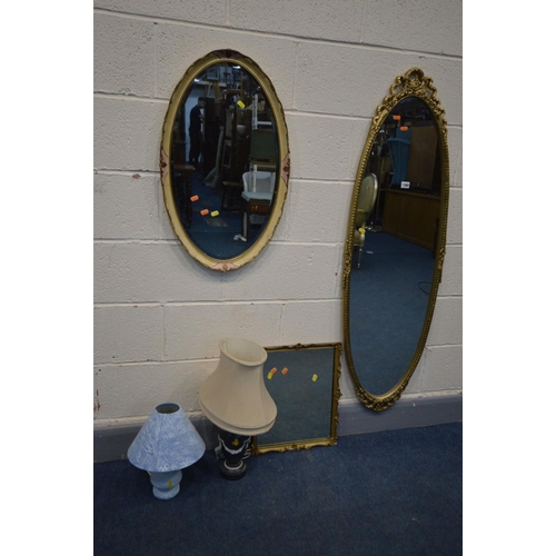 1382 - AN OVAL FOLIATE GILT WOOD WALL MIRROR, another gilt mirror and another mirror, along with two table ... 