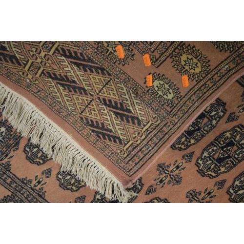 1387 - A WOOLEN PINK GROUND TEKKE RUG, 153cm x 93cm and a matching smaller rug (2)