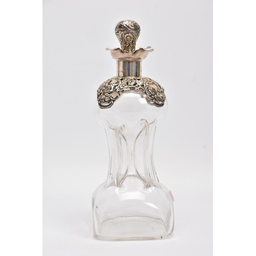 18 - AN EDWARDIAN GLASS AND SILVER DECANTER, the hour glass bottle with silver collar and stopper embosse... 