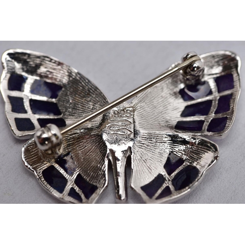 40 - A WHITE METAL ENAMELLED BUTTERFLY BROOCH, designed with purple guilloche enamelled wings, fitted wit... 