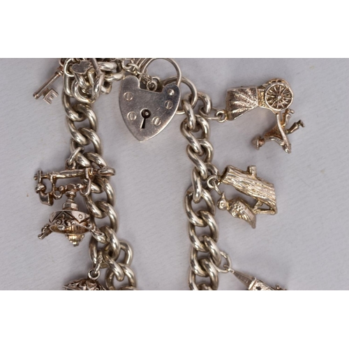 64 - TWO CHARM BRACELETS, the first suspending eight white metal charms in forms such as a bible, church,... 