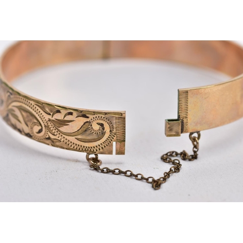 66 - TWO ROLLED GOLD HINGED BANGLES, one with an engraved floral design, the other with a textured design... 