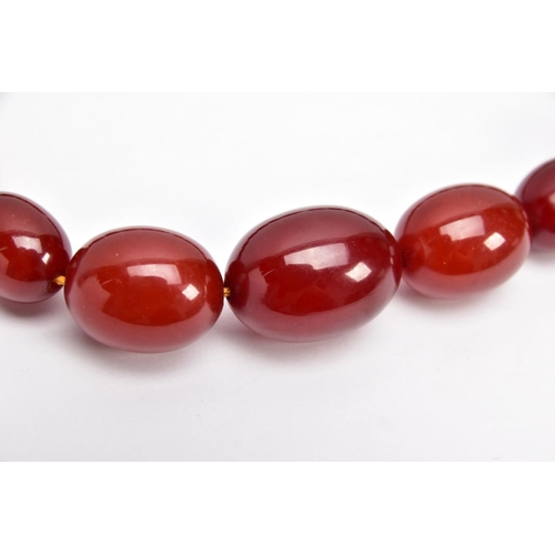 9 - A CHERRY AMBER GRADUATED BEAD NECKLACE, the largest measuring approximately 31.7mm x 23.3mm, the sma... 