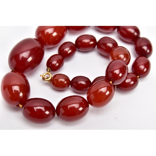 9 - A CHERRY AMBER GRADUATED BEAD NECKLACE, the largest measuring approximately 31.7mm x 23.3mm, the sma... 