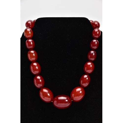 9 - A CHERRY AMBER GRADUATED BEAD NECKLACE, the largest measuring approximately 31.7mm x 23.3mm, the sma... 