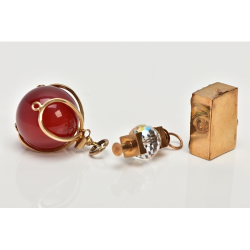 118 - THREE 9CT GOLD CHARMS, to include a carnelian bead charm with a scalloped wire mount, a lantern char... 