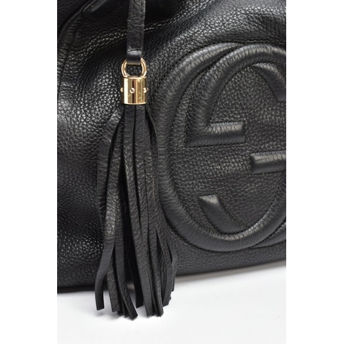 139 - A BLACK GUCCI BAG, the soft leather with raised double G symbol to front centre, tassel attached to ... 