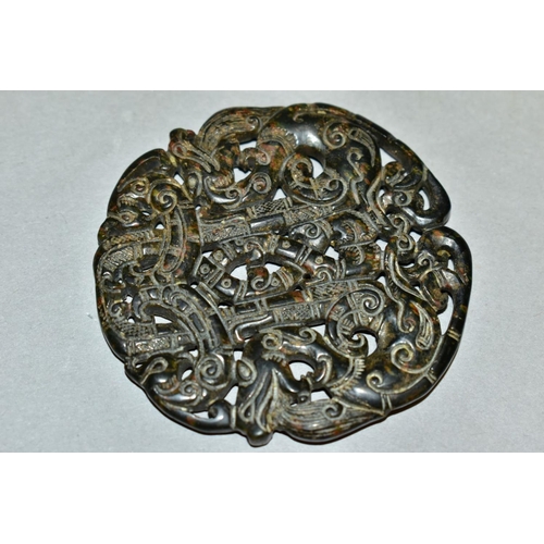 310 - A CHINESE CARVED AND PIERCED CIRCULAR HARDSTONE TABLET, with serpents and scrolls, diameter 6.7cm x ... 