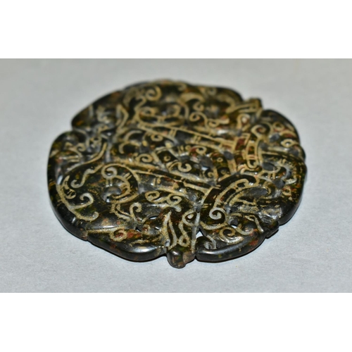 310 - A CHINESE CARVED AND PIERCED CIRCULAR HARDSTONE TABLET, with serpents and scrolls, diameter 6.7cm x ... 