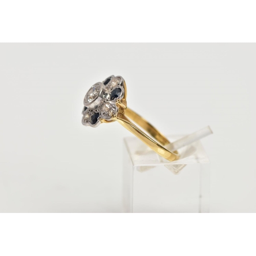 69 - AN 18CT GOLD DIAMOND AND SAPPHIRE CLUSTER RING, the central brilliant cut diamond within a collet se... 