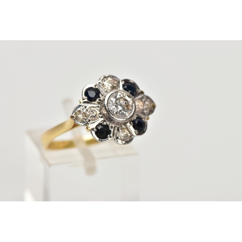 69 - AN 18CT GOLD DIAMOND AND SAPPHIRE CLUSTER RING, the central brilliant cut diamond within a collet se... 