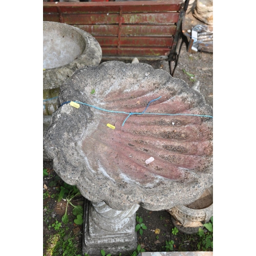 1009 - A LARGE COMPOSITE BIRDBATH with shell shaped top 52cm in diameter on a twisted baluster base with sq... 