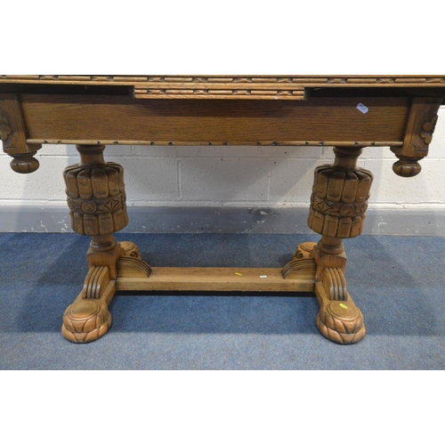 1207 - AN ART DECO LIGHT OAK DRAW LEAF TABLE, rose carving to each frieze corner, united by a H stretcher o... 