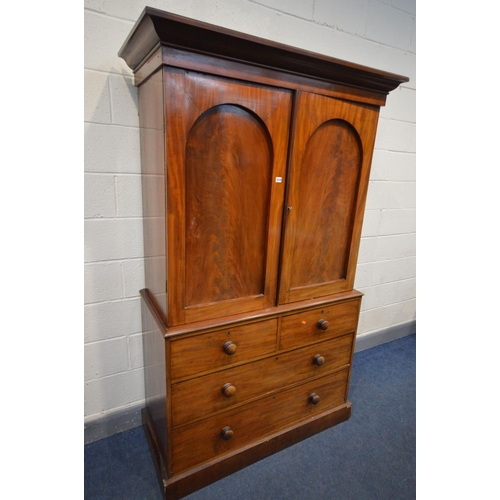 1214 - A VICTORIAN FLAME MAHOGANY LINEN PRESS, overhanging cornice, the double panelled doors enclosing thr... 