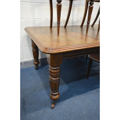 1306 - AN EDWARDIAN OAK WIND OUT DINING TABLE, with a single leaf, later fitted waiter's bell, on turned le... 