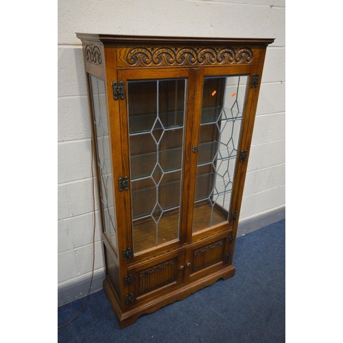 1342 - AN OAK OLD CHARM LEAD GLAZED DOUBLE DOOR CHINA CABINET, with three glass fixed shelves, above a doub... 