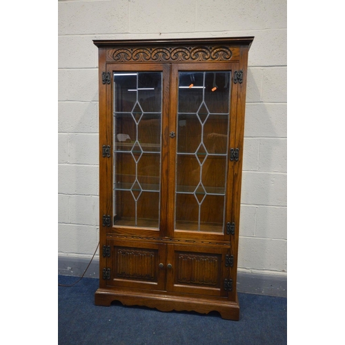 1342 - AN OAK OLD CHARM LEAD GLAZED DOUBLE DOOR CHINA CABINET, with three glass fixed shelves, above a doub... 