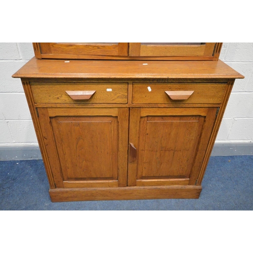 1365 - AN EARLY 20TH CENTURY OAK GLAZED TWO DOOR BOOKCASE, two drawers above two fielded panel doors, width... 