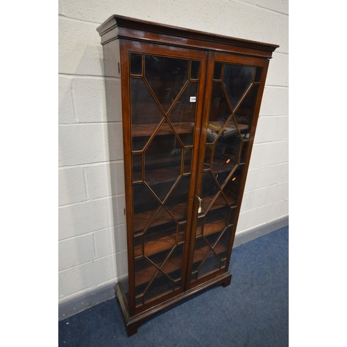 1379 - A GEORGIAN MAHOGANY TWO DOOR BOOKCASE, astragal glazing joined by inlaid partitions, enclosing five ... 