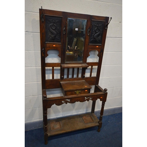 1490 - AN EARLY 20TH CENTURY OAK HALL STAND, with later tin panels flanking a bevelled edge mirror above a ... 