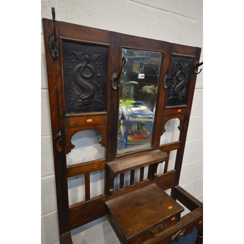 1490 - AN EARLY 20TH CENTURY OAK HALL STAND, with later tin panels flanking a bevelled edge mirror above a ... 