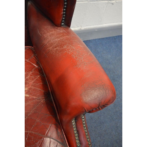 1505 - A BURGUNDY LEATHER BUTTONED WING BACK ARMCHAIR (condition - armrests worn, cracked and one rip, cush... 