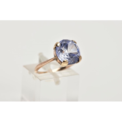 100 - A YELLOW METAL DRESS RING, designed with a claw set circular cut pale blue stone assessed as sapphir... 