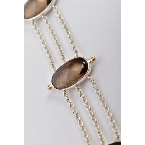 108 - A SILVER SMOKEY QUARTZ BRACELET, designed with four oval links set with smoky quartz cabochons, inte... 