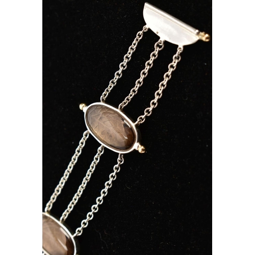 108 - A SILVER SMOKEY QUARTZ BRACELET, designed with four oval links set with smoky quartz cabochons, inte... 