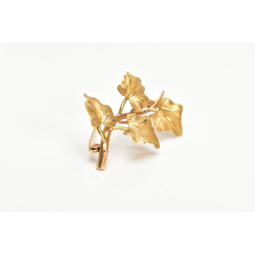 168 - A YELLOW METAL VINE LEAF BROOCH, textured vine leaves on a plain polished stem, fitted with a brooch... 