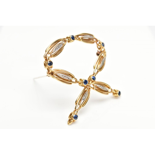 169 - A YELLOW METAL SAPPHIRE AND DIAMOND SET BROOCH, openwork cross over design, set with circular cut bl... 