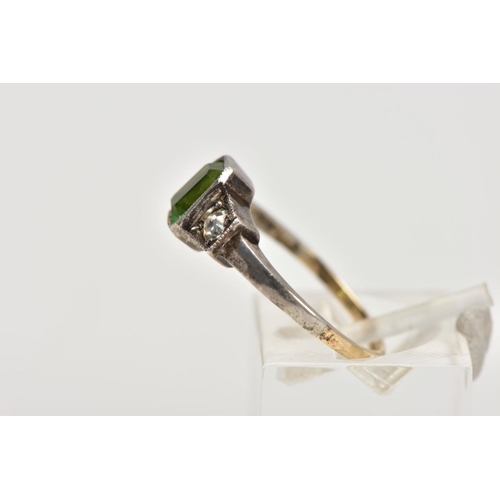 25 - A YELLOW AND WHITE METAL DRESS RING, centring on an emerald cut green paste, flanked with circular c... 