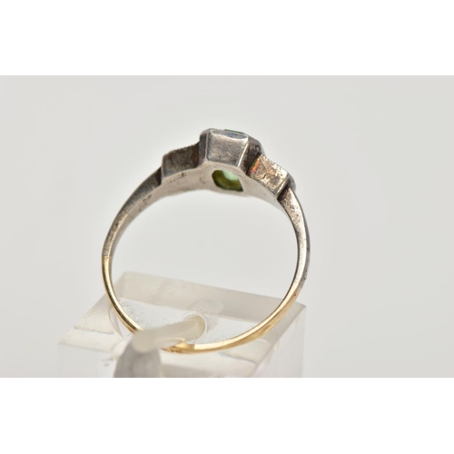 25 - A YELLOW AND WHITE METAL DRESS RING, centring on an emerald cut green paste, flanked with circular c... 