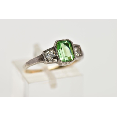 25 - A YELLOW AND WHITE METAL DRESS RING, centring on an emerald cut green paste, flanked with circular c... 