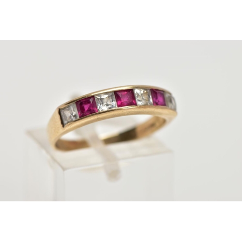 28 - A 9CT GOLD HALF ETERNITY RING, designed with a row of channel set square cut rubies interspaced with... 