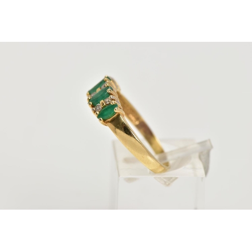 31 - A YELLOW METAL EMERALD AND DIAMOND HALF ETERNITY RING, designed with a row of four marquise cut emer... 