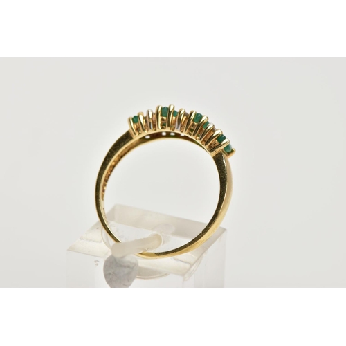 31 - A YELLOW METAL EMERALD AND DIAMOND HALF ETERNITY RING, designed with a row of four marquise cut emer... 