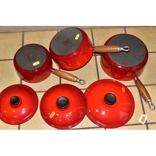 371 - A GRADUATED SET OF THREE LE CREUSET RED ENAMEL SAUCEPANS AND LIDS, wooden handles, diameters 16cm, 1... 