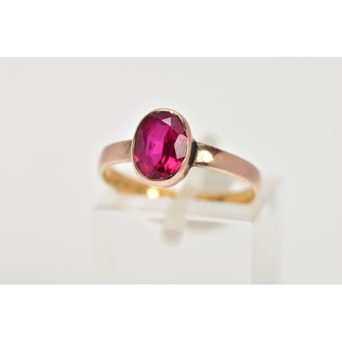 41 - A 22CT GOLD VICTORIAN DRESS RING, set with an oval cut synthetic ruby within a collet mount, plain p... 