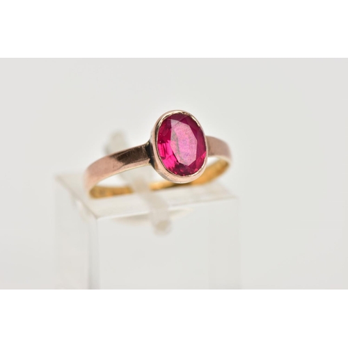 41 - A 22CT GOLD VICTORIAN DRESS RING, set with an oval cut synthetic ruby within a collet mount, plain p... 