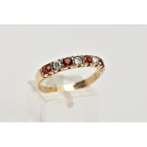 42 - A 9CT GOLD GARNET AND CUBIC ZIRCONIA HALF ETERNITY RING, designed with a row of four circular cut ga... 