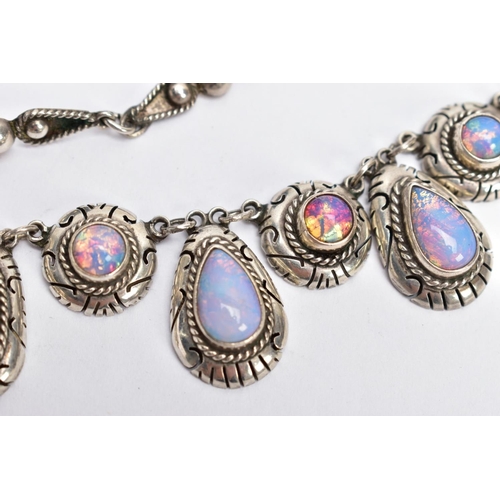 47 - A WHITE METAL AND FAUX OPAL CABOCHON NECKLET, designed with eight circular links each set with a fau... 