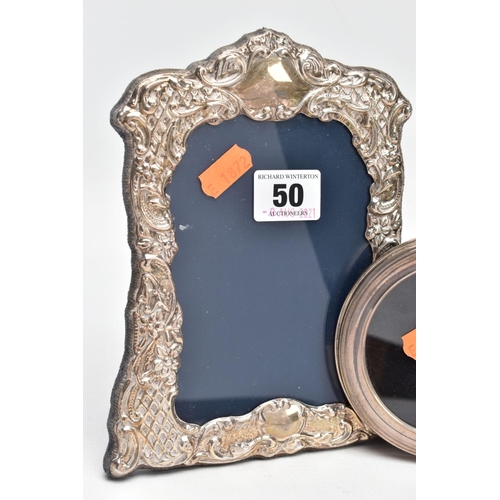 50 - TWO SILVER PHOTOFRAMES, the first of a wavy rectangular form, embossed floral and foliate design wit... 