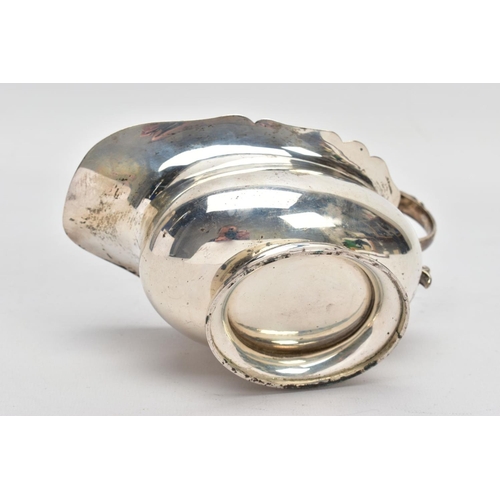 53 - A GEORGE V SILVER SAUCE BOAT, plain polished body, wavy detailed rim, scroll and leaf detailed handl... 