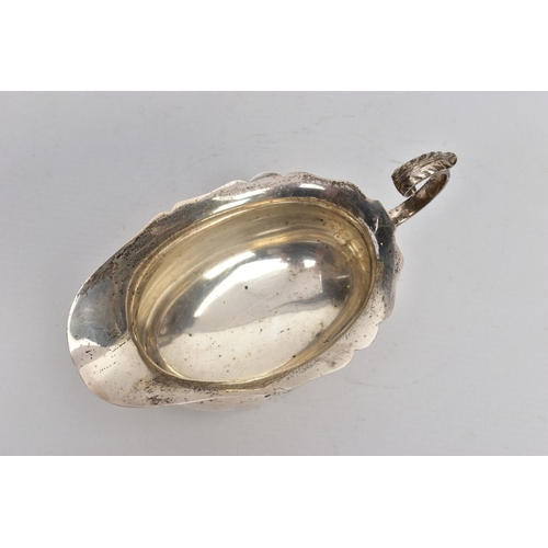 53 - A GEORGE V SILVER SAUCE BOAT, plain polished body, wavy detailed rim, scroll and leaf detailed handl... 