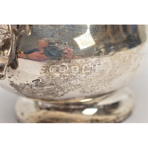 53 - A GEORGE V SILVER SAUCE BOAT, plain polished body, wavy detailed rim, scroll and leaf detailed handl... 