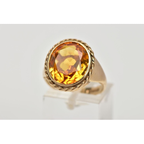 57 - A 9CT GOLD SYNTHETIC ORANGE SAPPHIRE DRESS RING, designed with a large oval cut synthetic orange sap... 