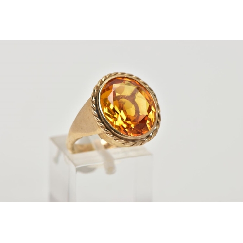 57 - A 9CT GOLD SYNTHETIC ORANGE SAPPHIRE DRESS RING, designed with a large oval cut synthetic orange sap... 